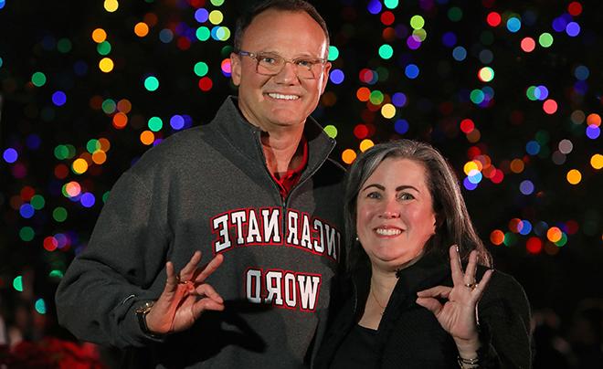 Dr. and Mrs. Evans against Christmas lights